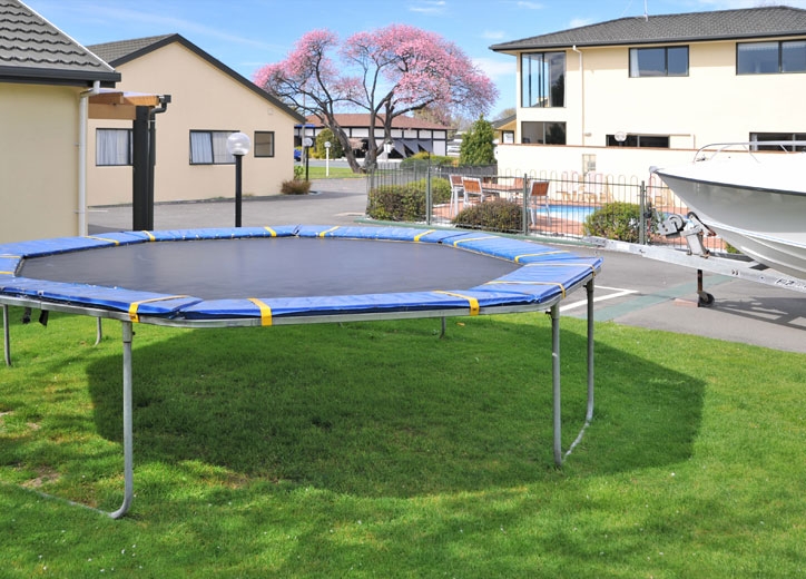 playground has a trampoline, swing and slide